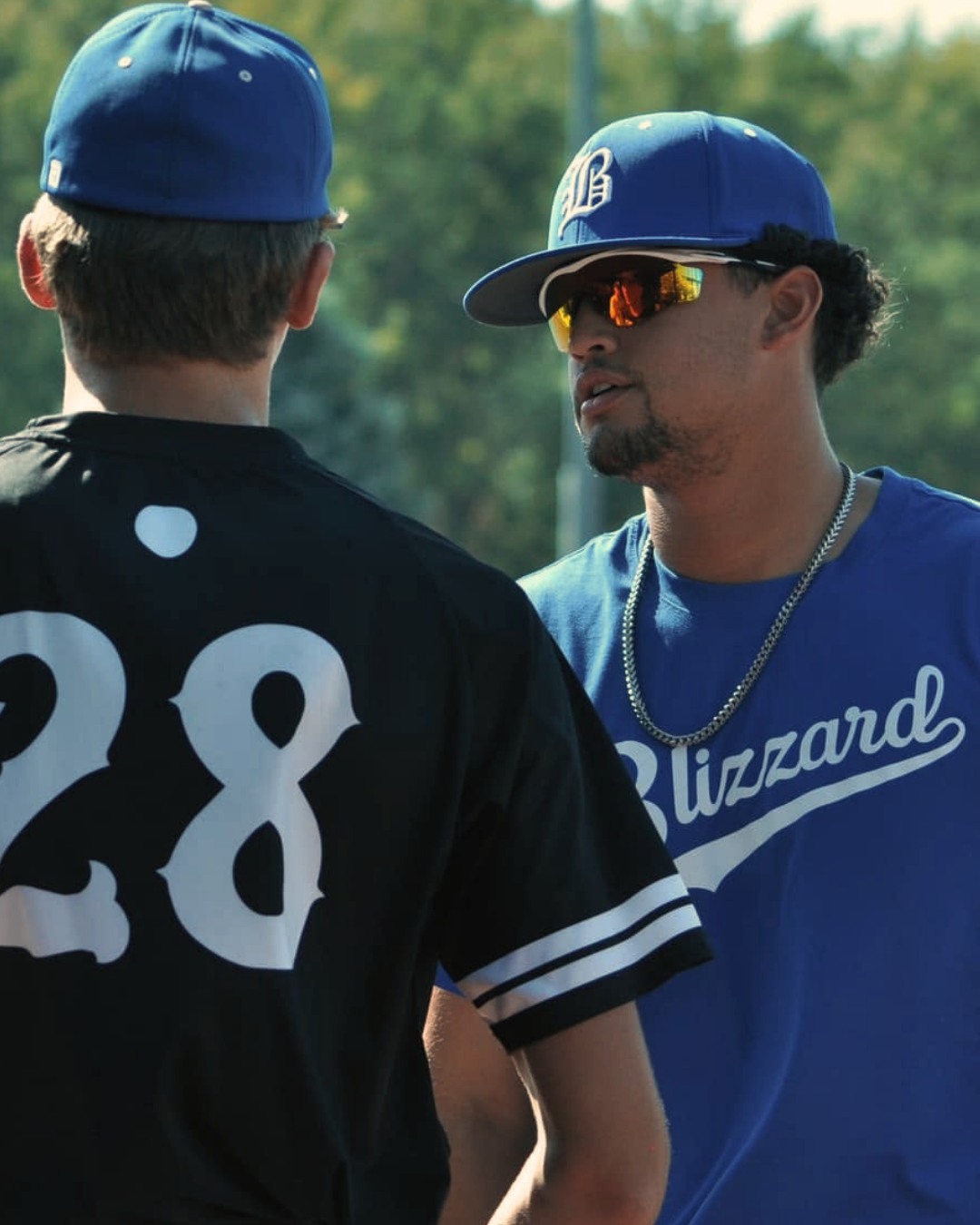 Bryan Sanchez talking with a player wearing a number 28 jersey during practice.